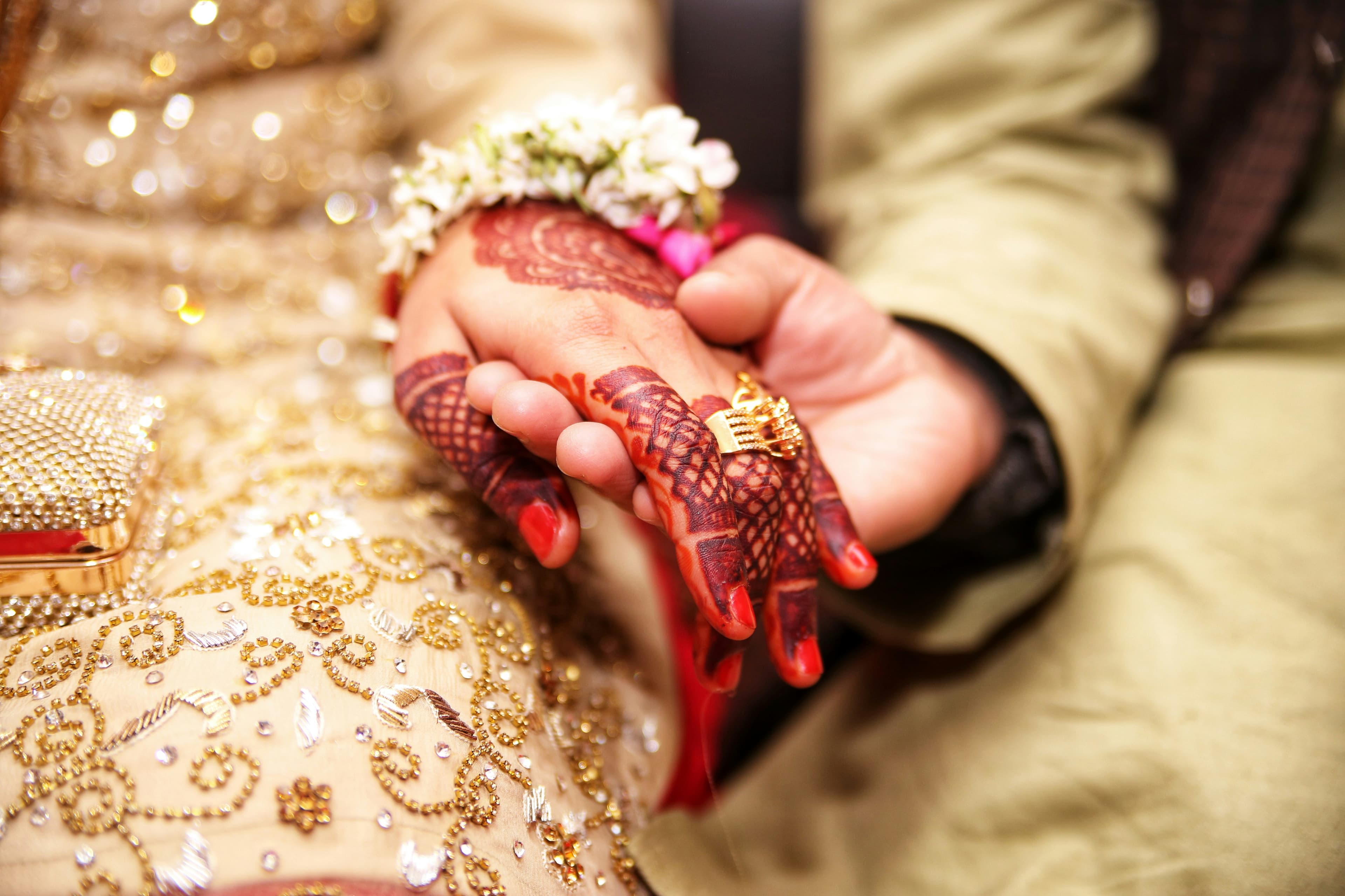 Couple holding hands — mehndi and wedding details
